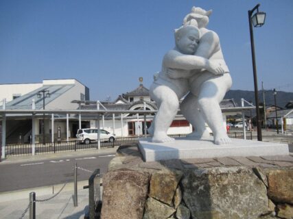 安土駅南口の、安土と相撲モニュメントの力士像と、あるおばはん。