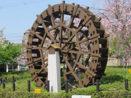 淀駅前の、淀の水車の碑と河津桜でございます。