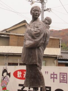 子守唄の里高屋駅高架下にある、中国地方の子守唄顕彰碑と像。