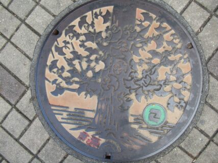 狛江駅北口広場周辺にあった、狛江市のオリジナルマンホール蓋。